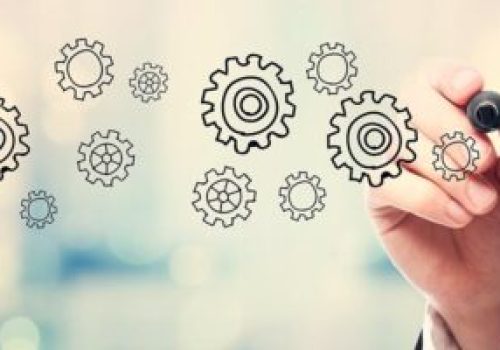 Businessman drawing Gear concept on blurred abstract background